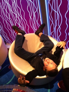 A boy sitting upside-down in a chair